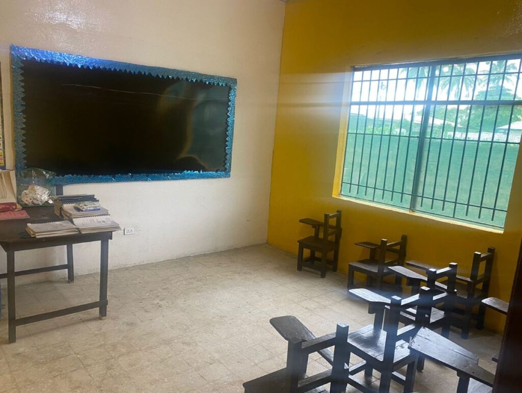 Interior view of a brightly lit, recently renovated classroom with clean desks and colorful wall posters at Zoe Robinson Academy.