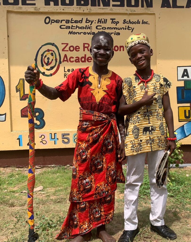 Two students at Zoe Robinson Academy smiling in traditional clothing during African Costume Day.