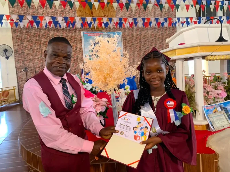 6th grade graduate, Asatu, receives her deploma from the Ministry of Education